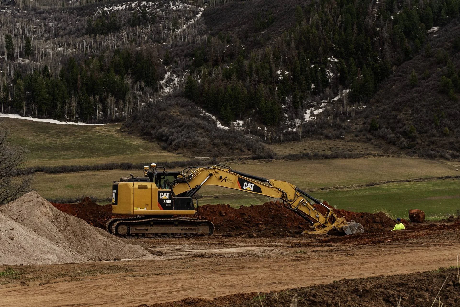 Cat excavator grading an open field